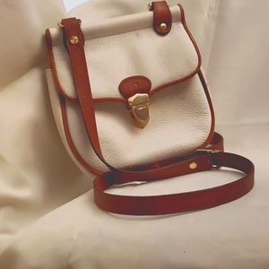 Adjustable, white all leather shoulder bag with rolled brown leather detailing.